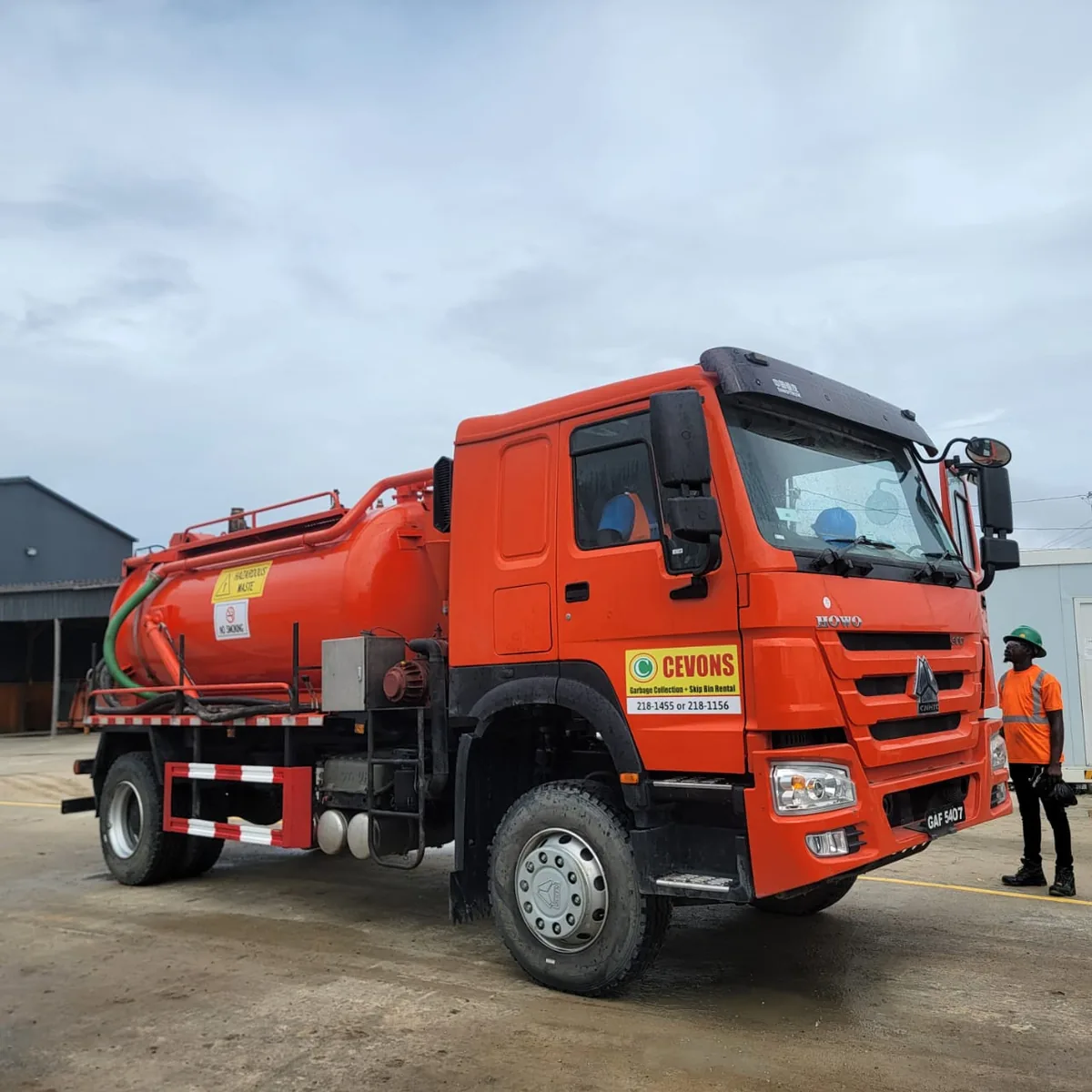 A CEVONS vacuum tanker on site in Guyana with a CEVONS operator in high-visibility gear